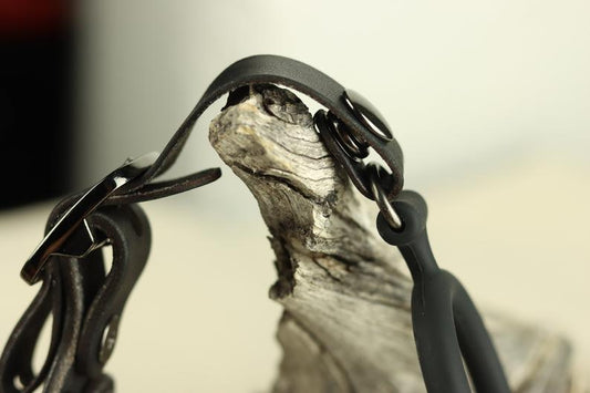 A closeup of the locking mechanism for the bdsm leather head harness that allows the user to interchange the ring gag for a ballgag or a bit gag.