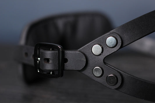 A side view of the black metal hardware on the leather blindfold. 