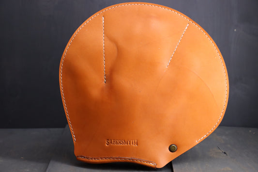 the leather spanking glove is pictured. It is a round piece of leather, with detailed stiching around the edges, and stitching to create a clear leather glove area for the wearer's hand.