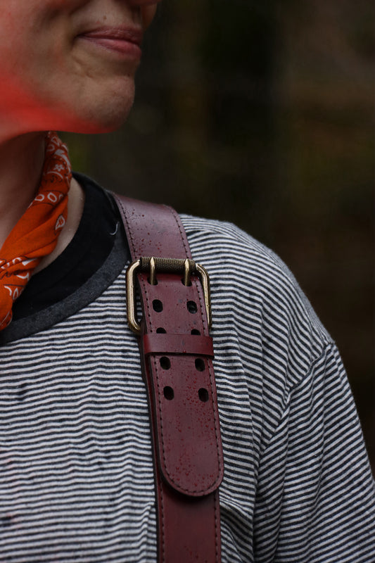 Closeup of the shoulder buckle on the leather suspenders. 